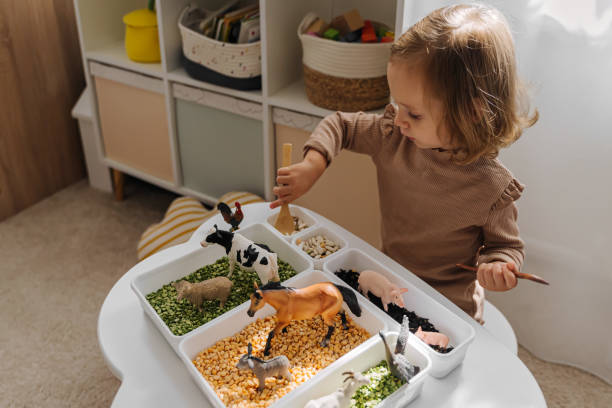 Child practicing independent play with a farm animal activity tray