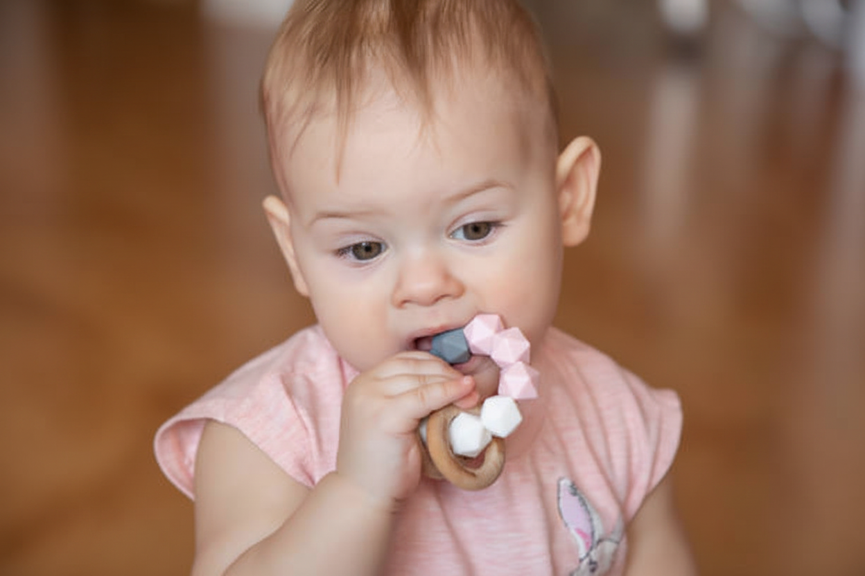 Baby chewing on a wooden teether