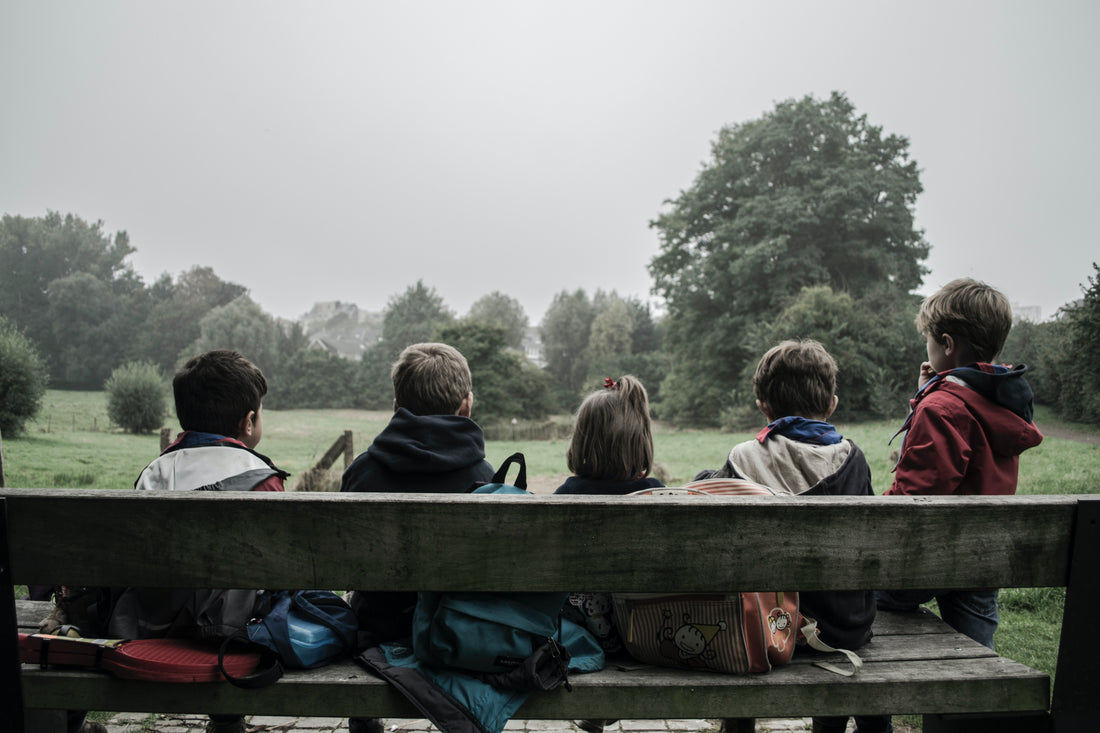 children sitting on a park bench