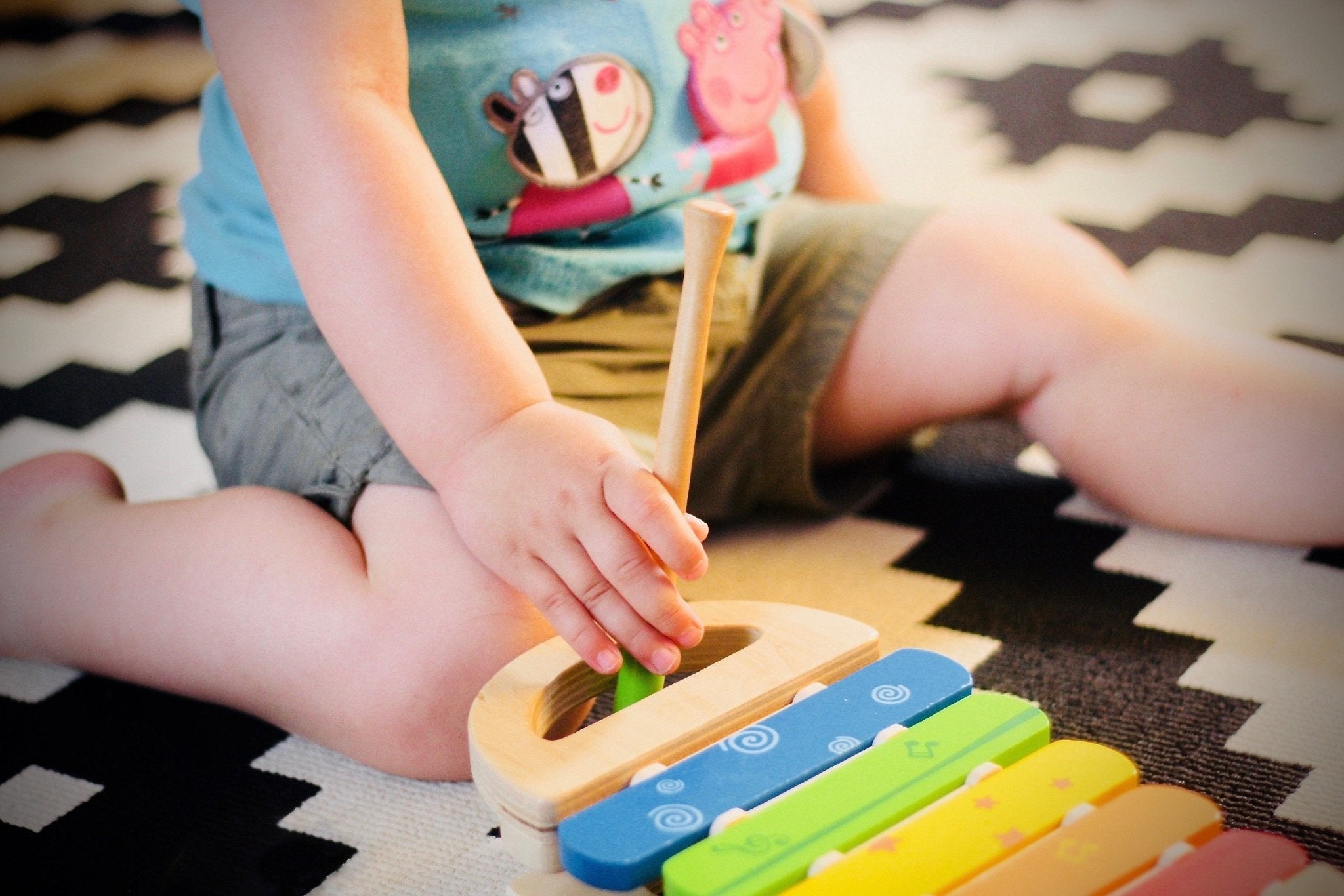 Child engaged in Montessori sensory play with wooden toys from Oliver and Company