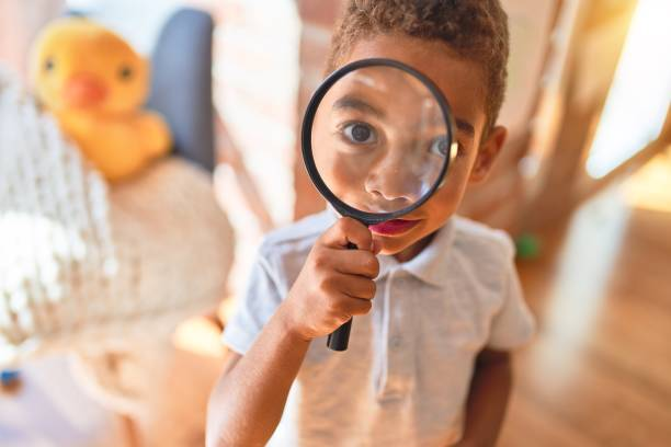 Child examining a toy with a magnifying glass during play