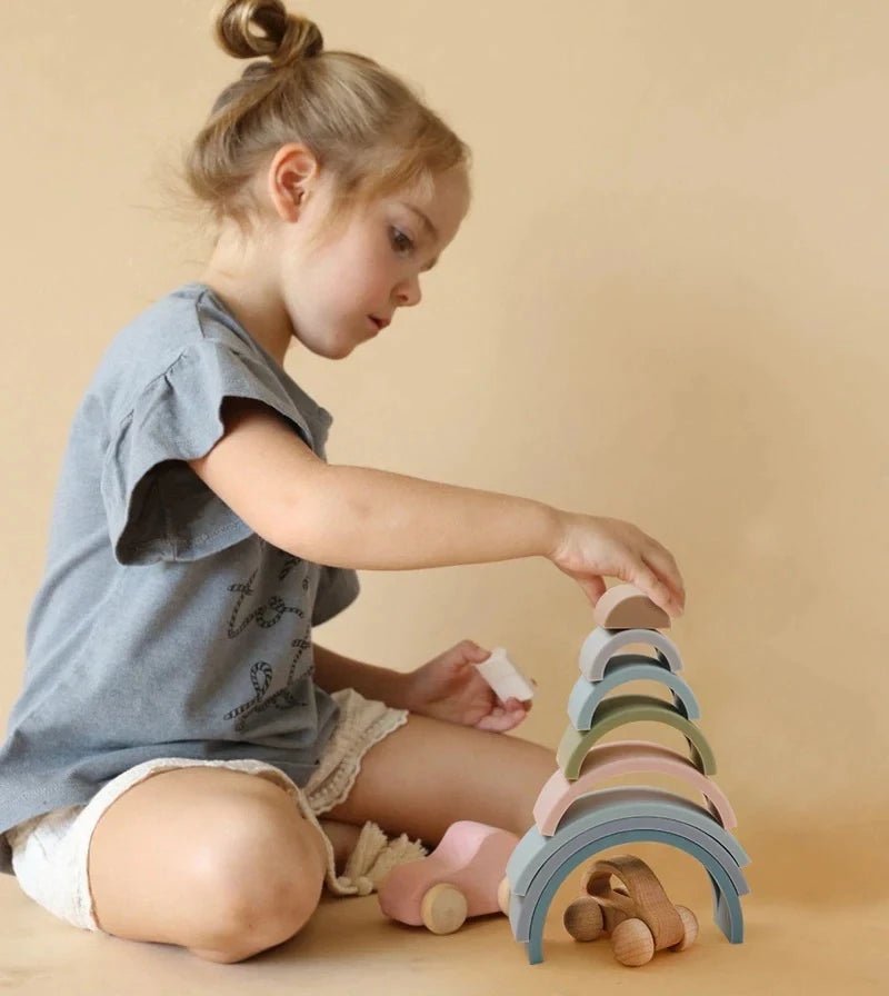 A toddler plays with colorful wooden blocks, embodying Oliver & Company Montessori Toys' focus on eco-friendly, educational play for early learning and creativity.