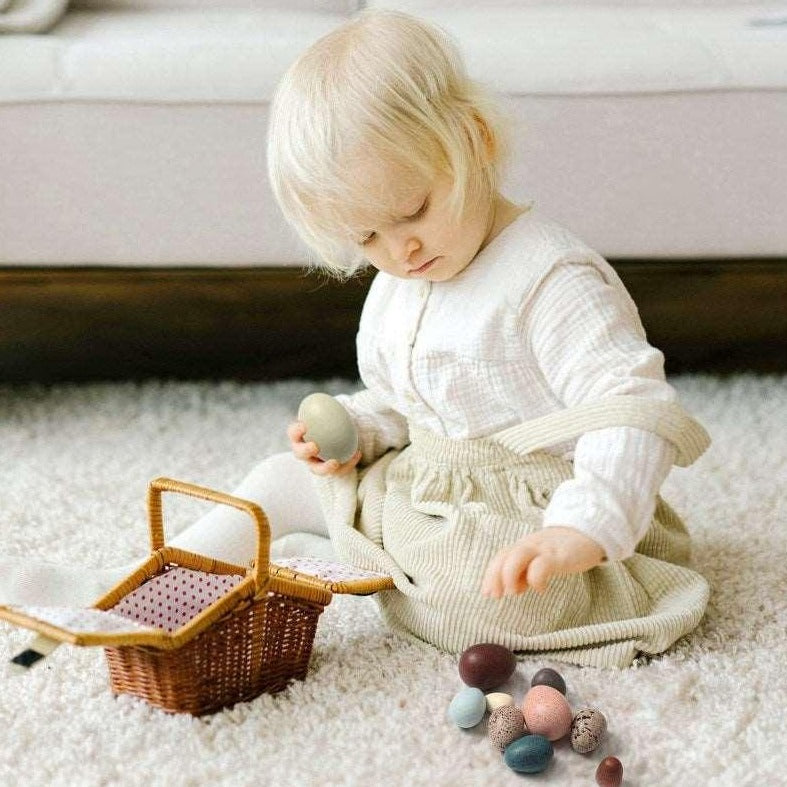 child playing with bird eggs
