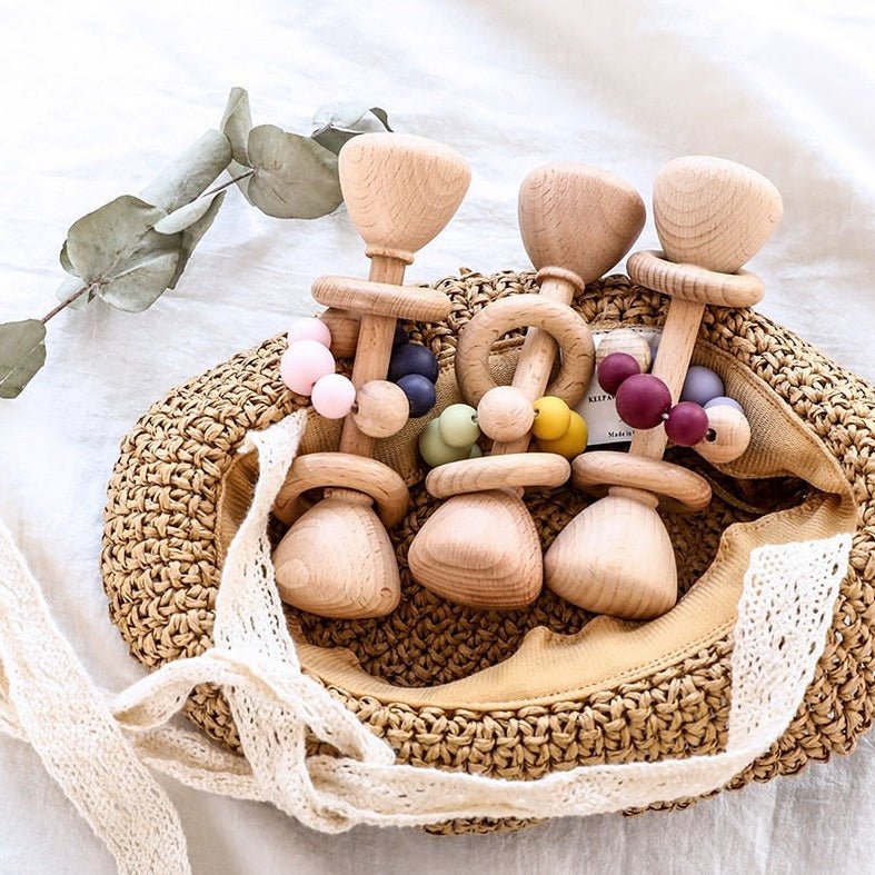 Montessori Beech Wood Baby Rattle in a basket with wooden toys, designed for tactile and auditory development.