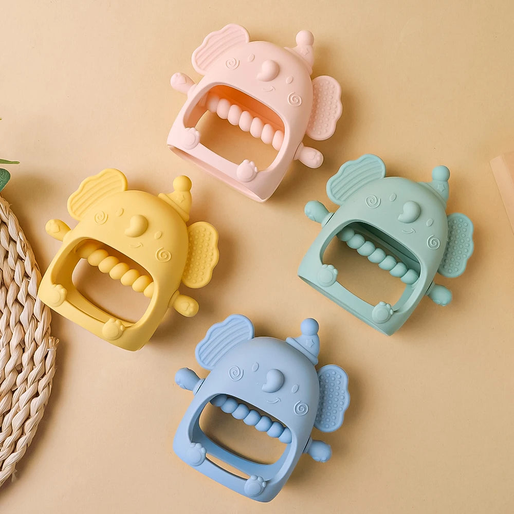 Four colorful silicone baby teether toys on a beige background