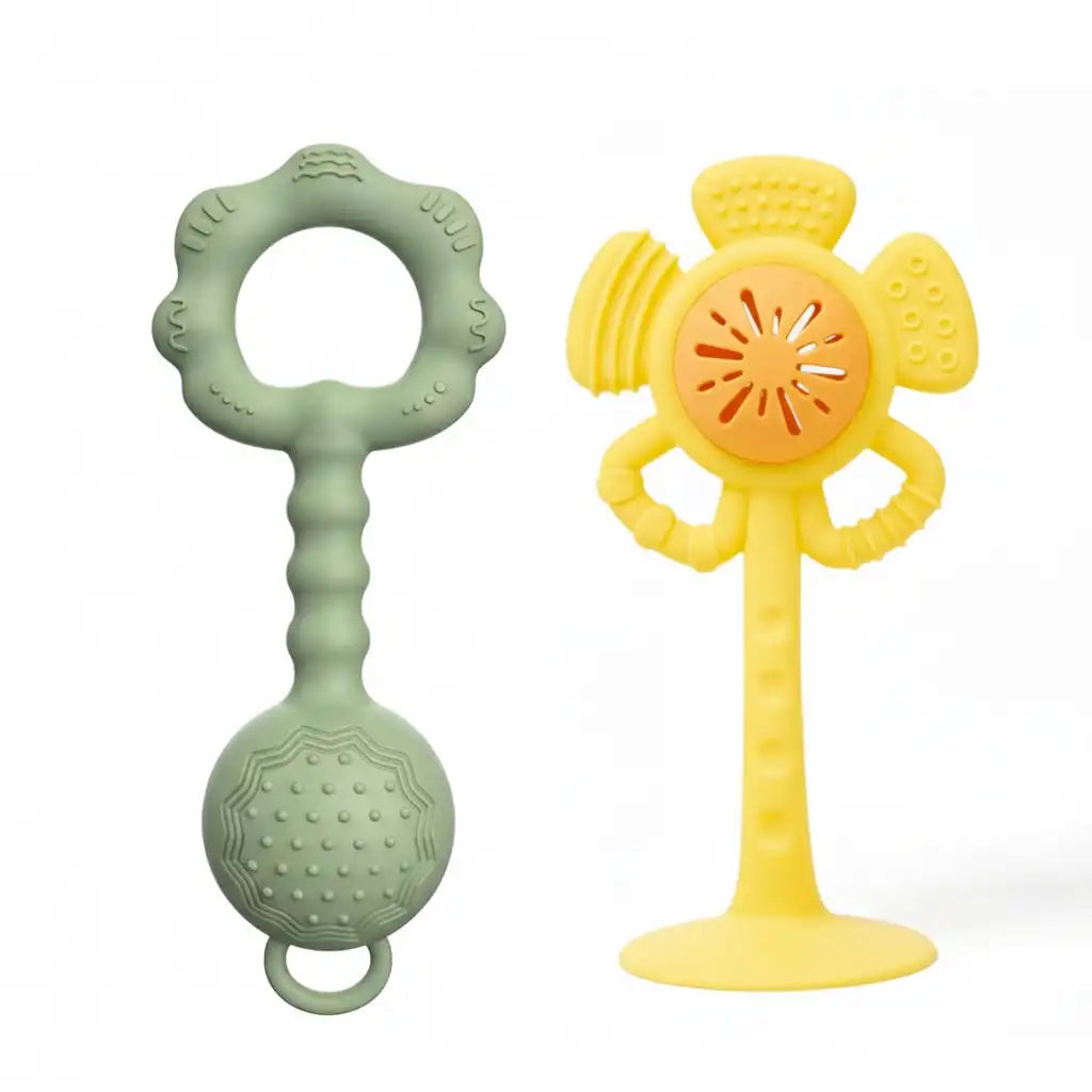 Two silicone baby teething toys on a white background: a mint green ring teether with a textured ball on the handle, and a yellow flower-shaped teether with a suction base and orange center.