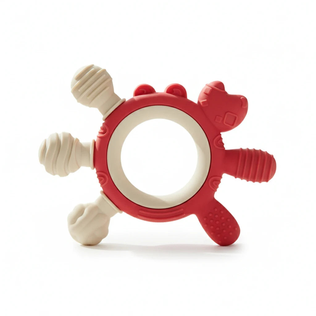 A red and off-white silicone baby teether with textured sensory bumps and a ring-shaped center, photographed on a clean white background.