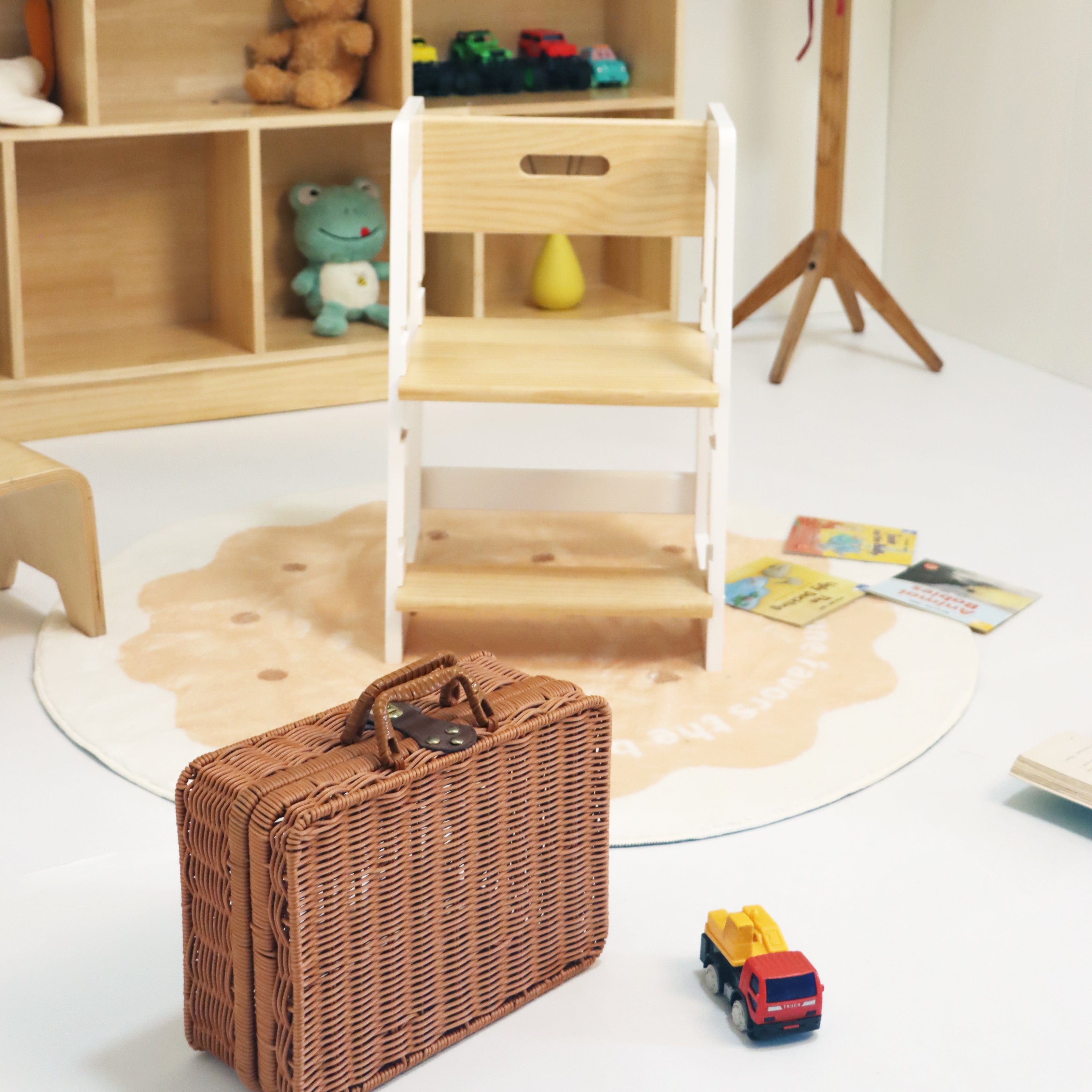 Children's playroom with wooden shelves, toys, and a wicker suitcase.