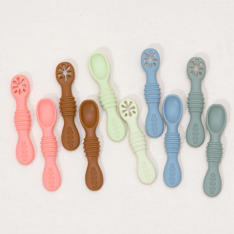 Bendable silicone baby spoons in many colors laid out in pairs