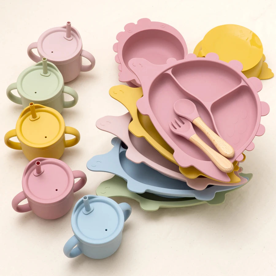 Colorful children's dining set including plates, cups, and utensils on a light background