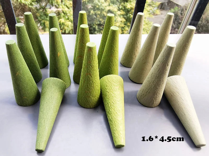 Set of green wooden cones on a white surface with a blurred outdoor background