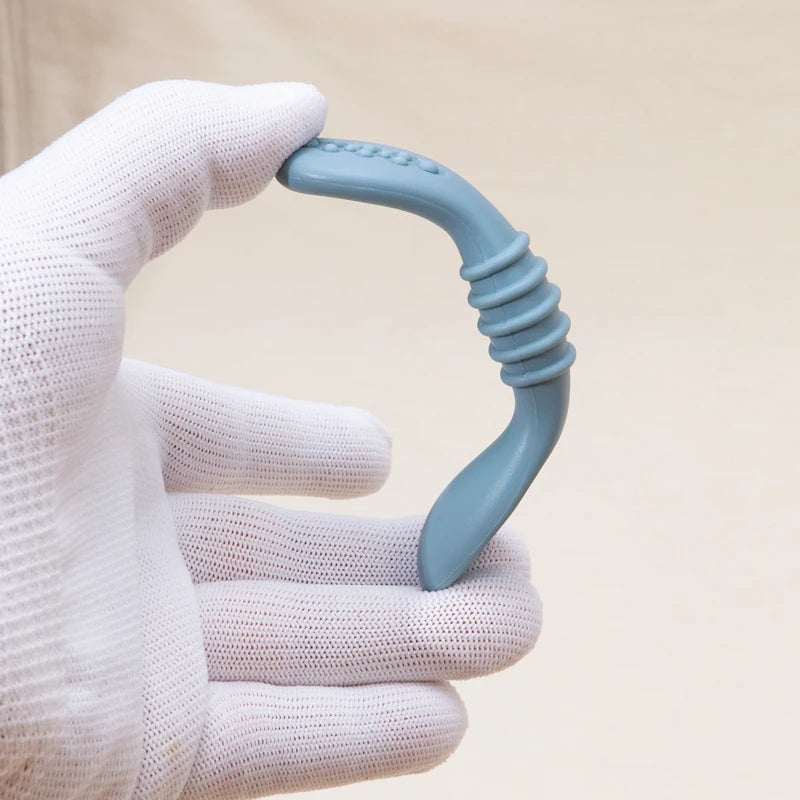Gloved hand bending a flexible silicone baby spoon