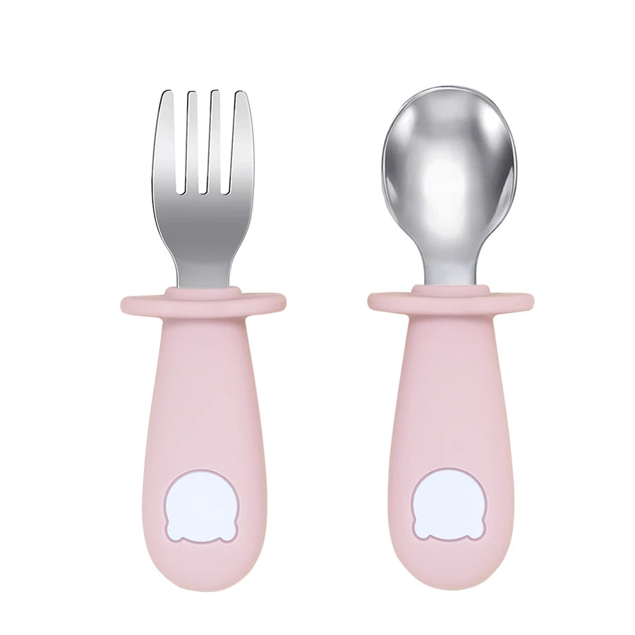 Set of baby fork and spoon with pink handles on a white background