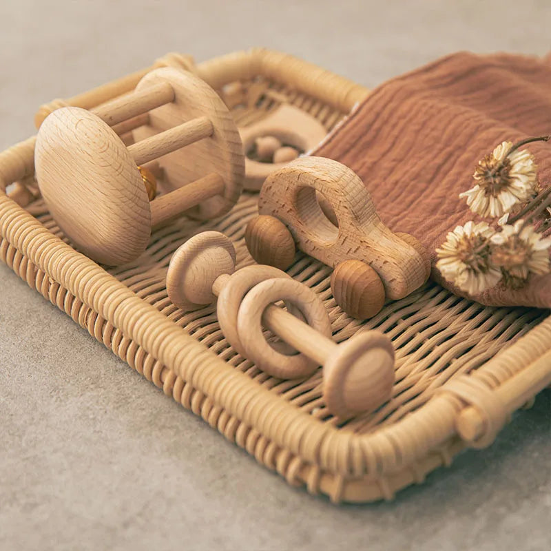 Montessori Baby Beech Wood Rattle Sets in a basket with flowers, showcasing eco-friendly design perfect for developing fine motor skills in infants.