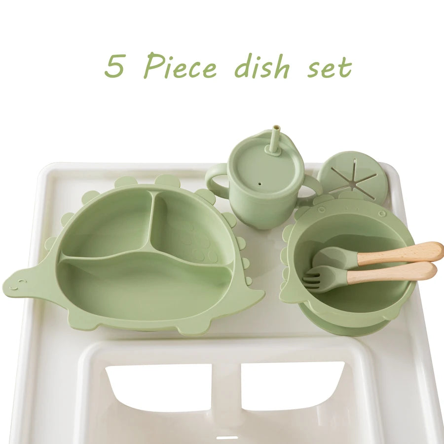Five-piece green dish set with a tray, bowl, cup, and utensils on a white background.
