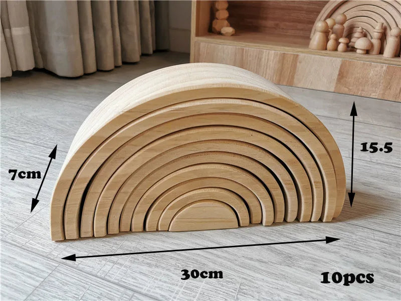 Wooden rainbow-shaped toy with measurements on a wooden floor