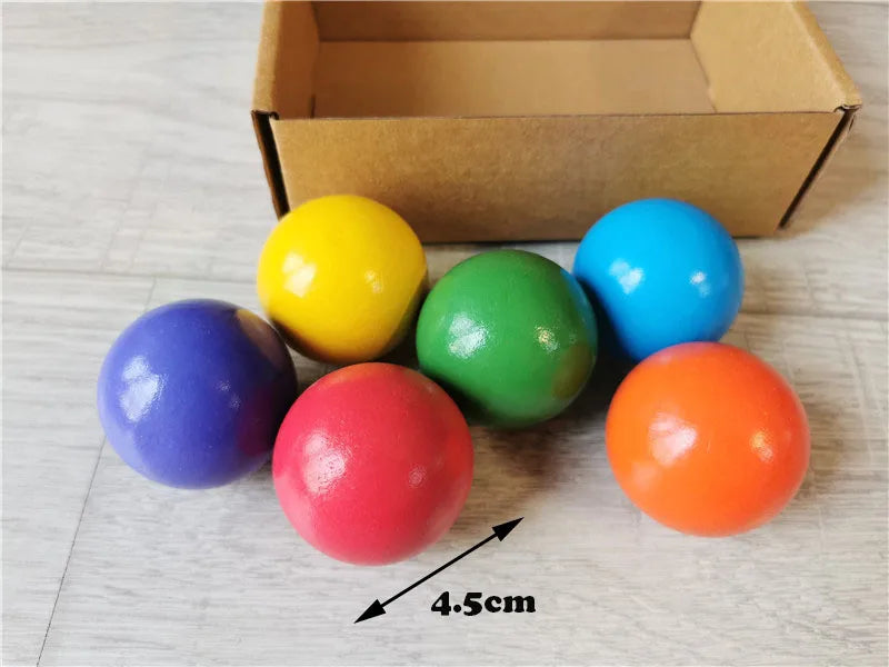 Colorful balls with a cardboard box on a light wooden surface