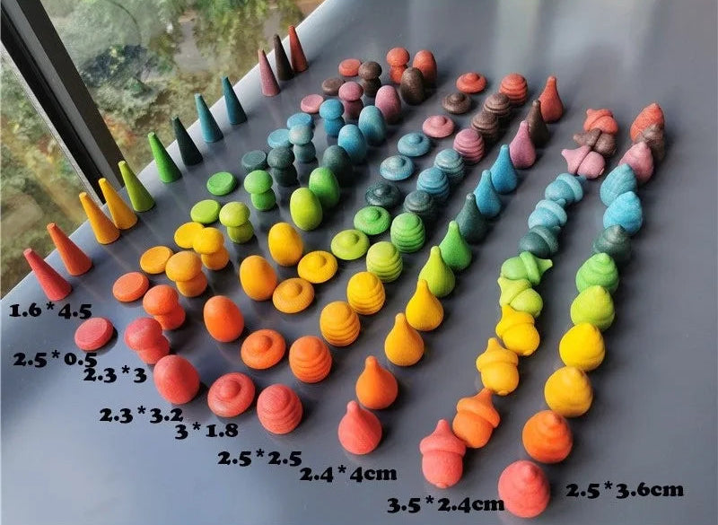 Colorful loose partsof various sizes on a gray surface with measurements.