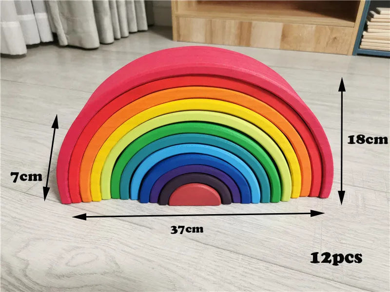 Colorful wooden rainbow toy with measurements on a light wooden floor.
