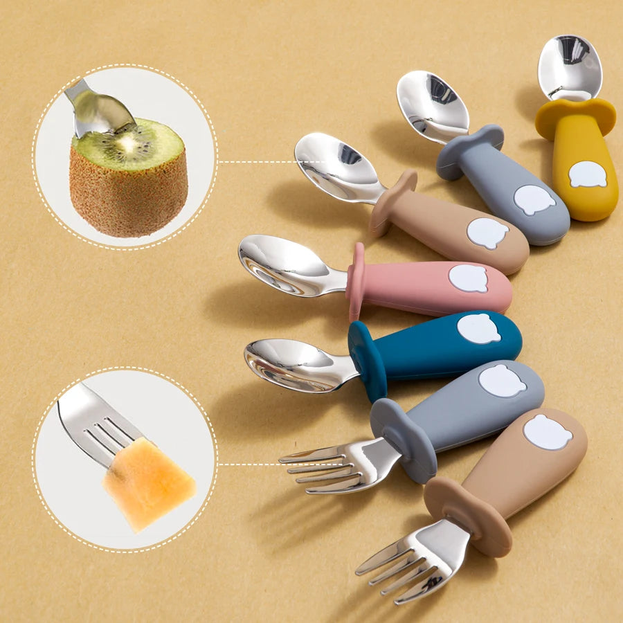 Colorful children's utensils with silicone handles on a beige background