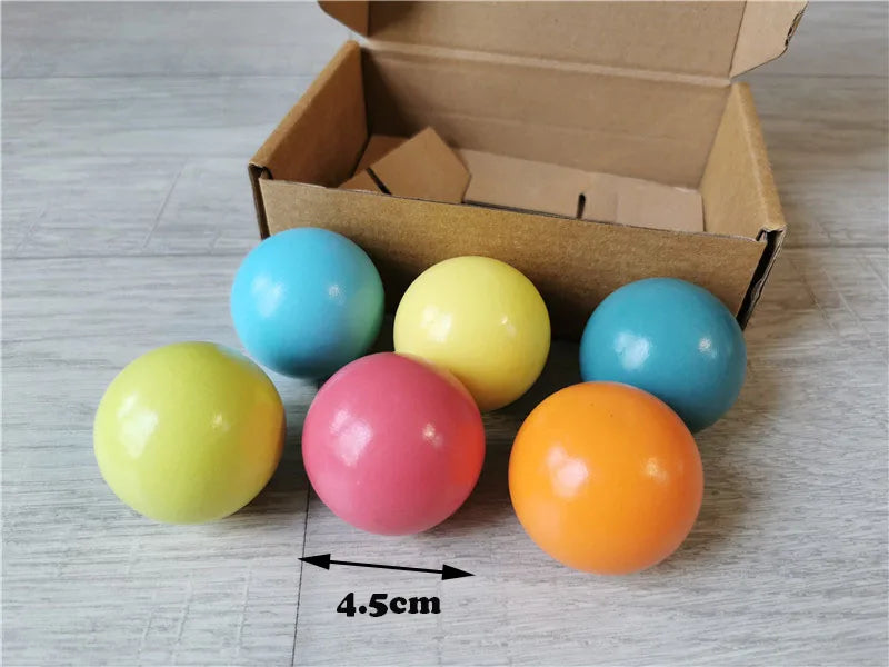 Colorful balls with a cardboard box on a wooden surface