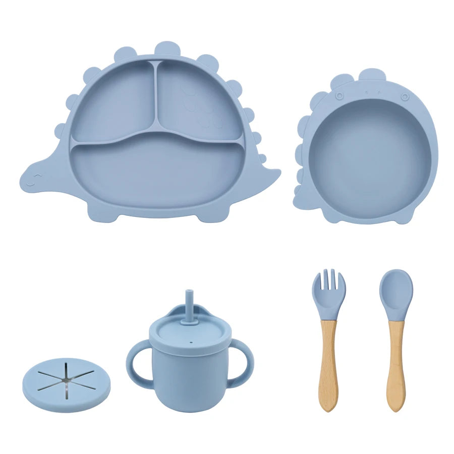 Blue silicone dining set with plate, bowl, cup, fork, and spoon on a white background