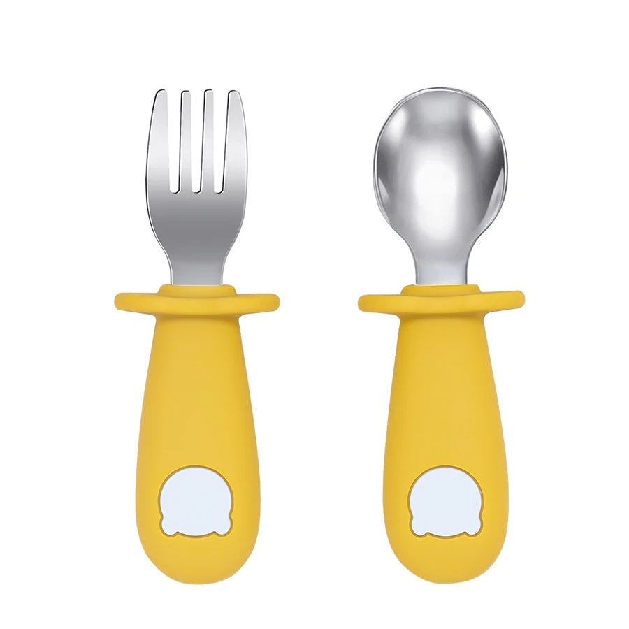 Set of silver fork and spoon with yellow handles on a white background