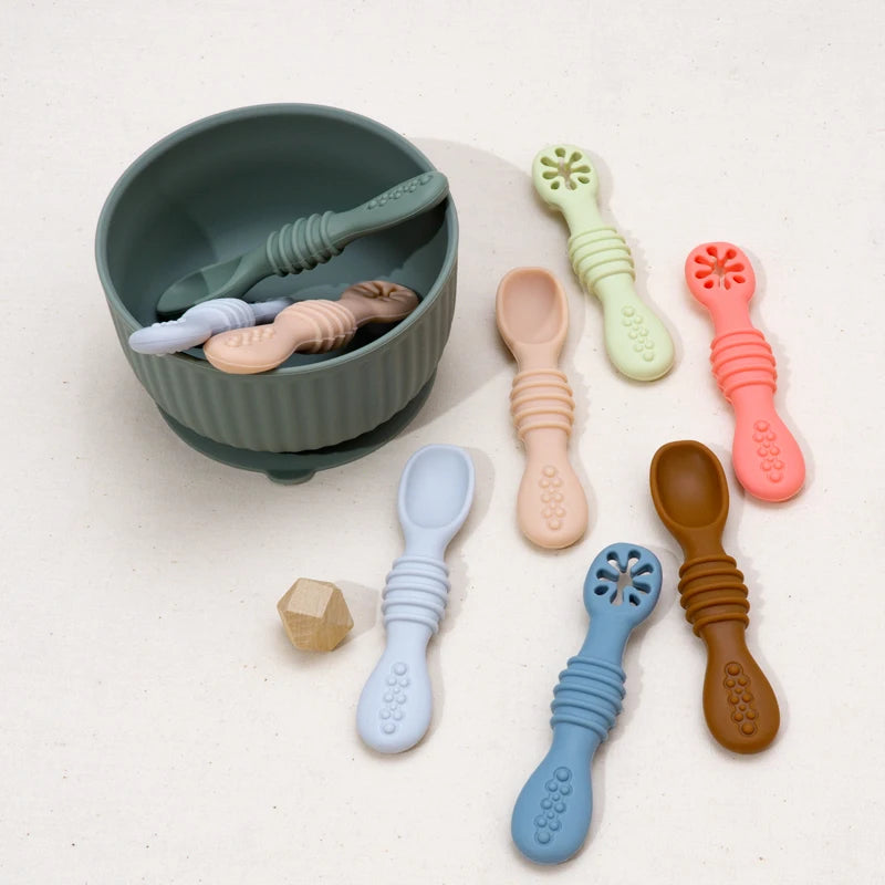 Silicone baby spoons around a green suction bowl