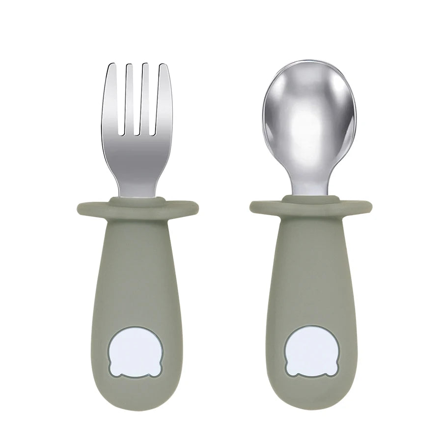 Set of silver fork and spoon with green handles on a white background