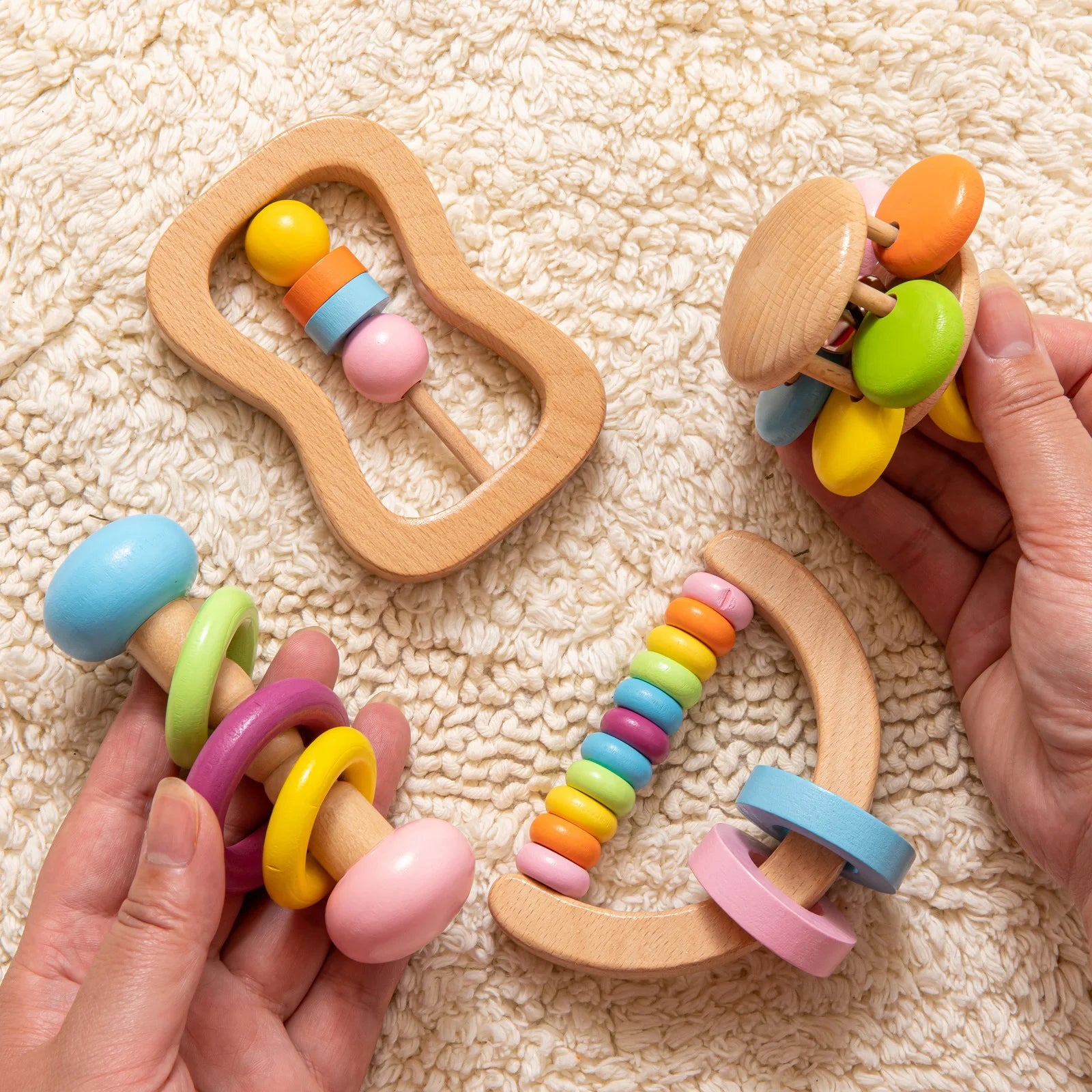 Colorful wooden baby rattle toys on a textured surface