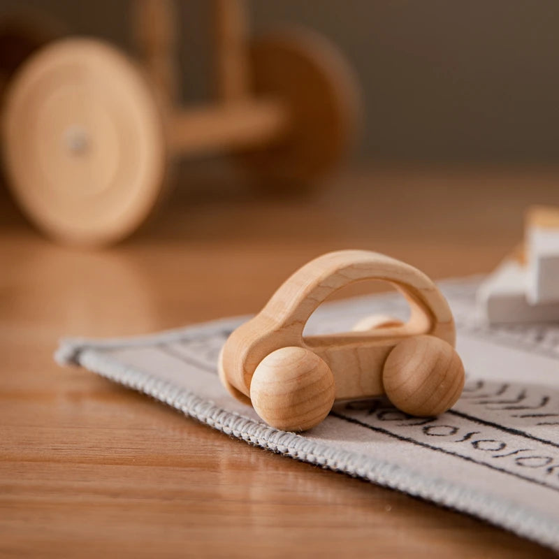 Wooden toy car on a wooden surface with a blurred background