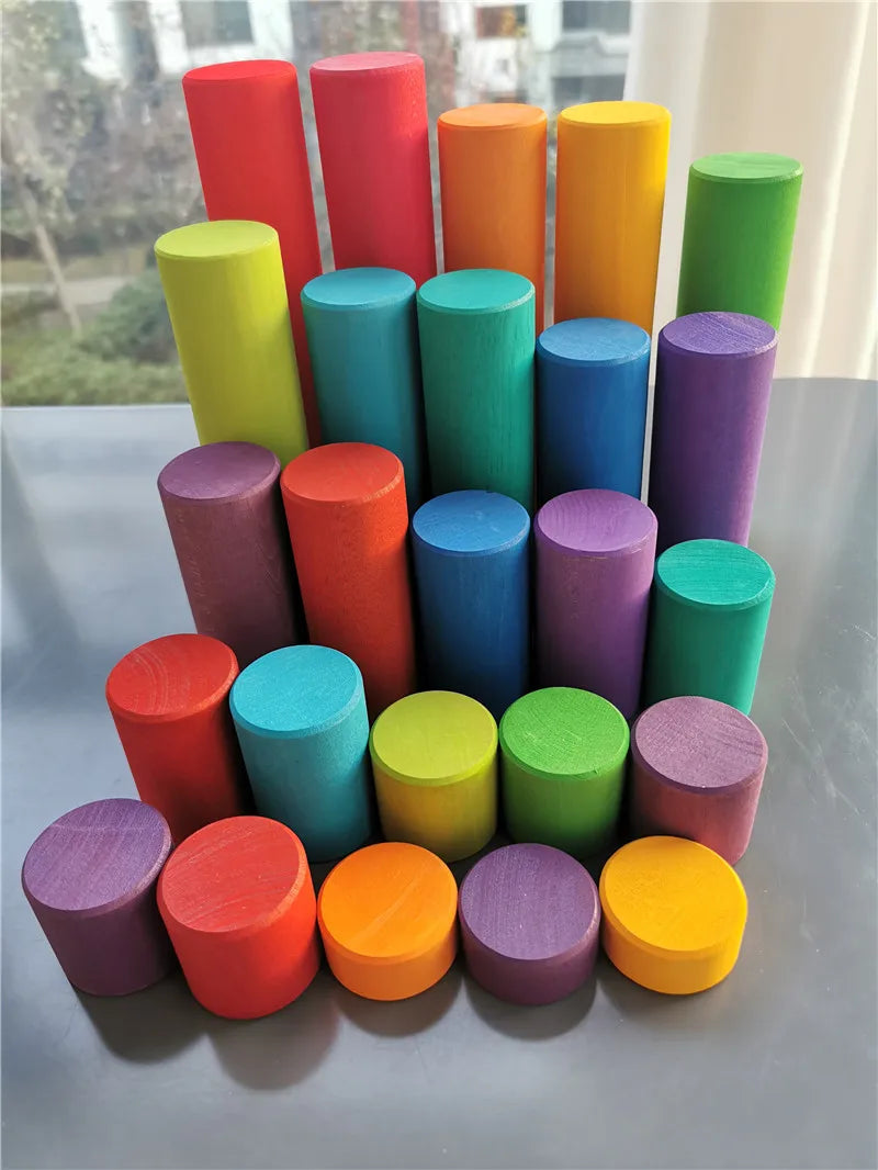 Colorful cylindrical objects arranged in a pyramid shape on a reflective surface.