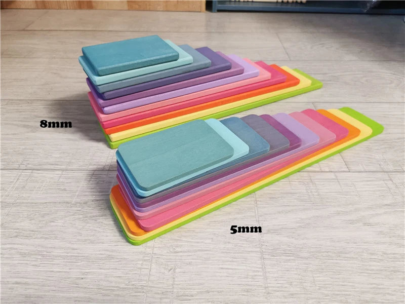 Stacks of colorful wooden slats with thickness labels on a wooden floor.