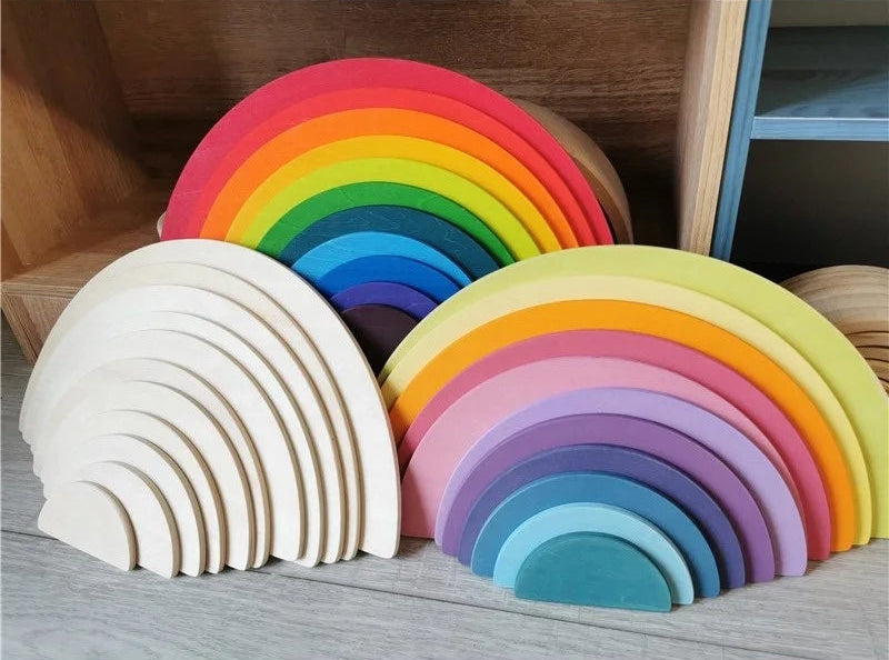Set of colorful wooden rainbow toys on a wooden surface.