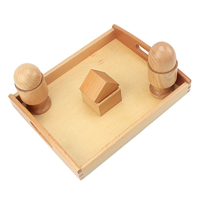 Egg and ball in cups on a wooden tray