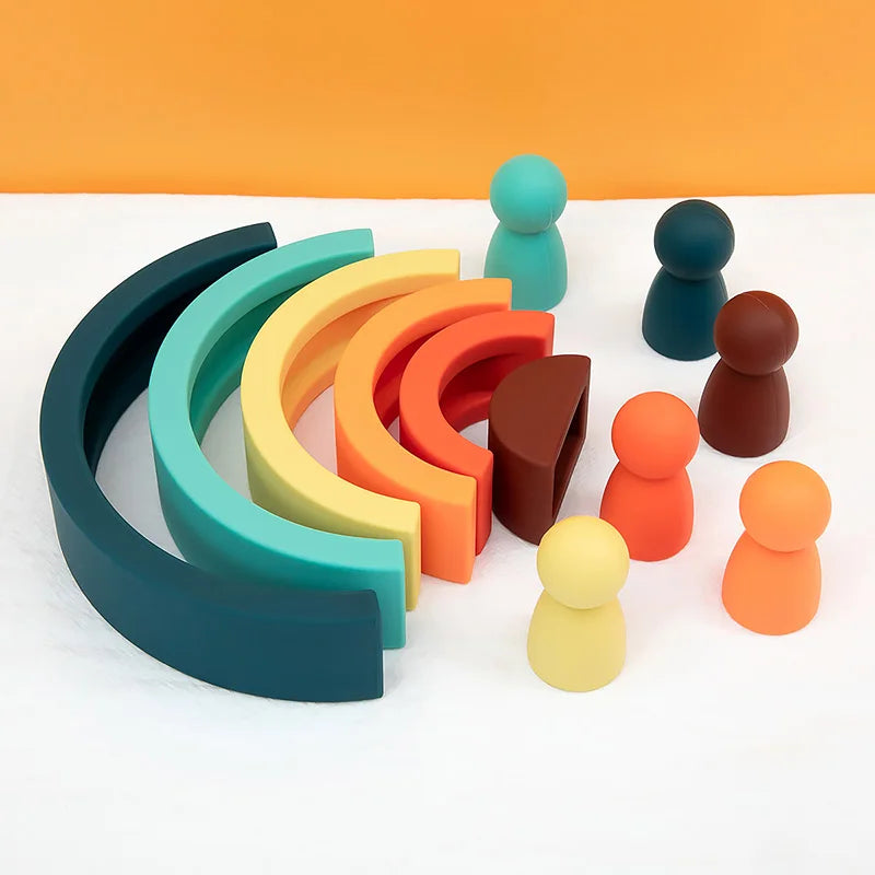 Colorful wooden toys including arches and cylindrical figures on a white surface with an orange background