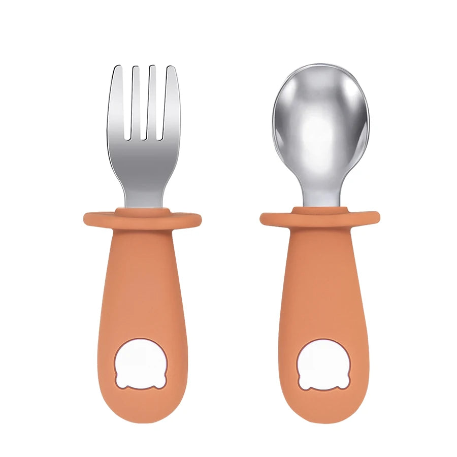 Set of silver fork and spoon with terracotta handles on a white background