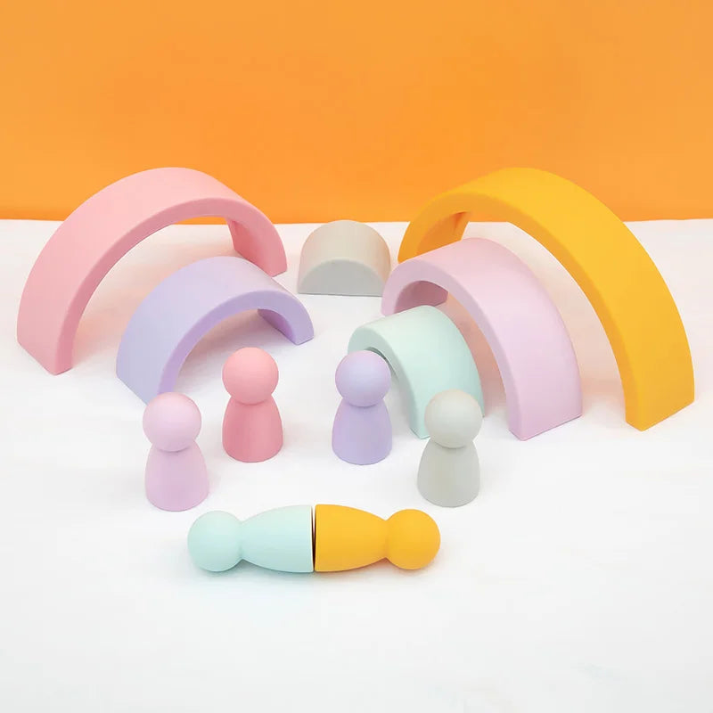 Pastel-colored wooden arches and figures on a white surface with an orange background