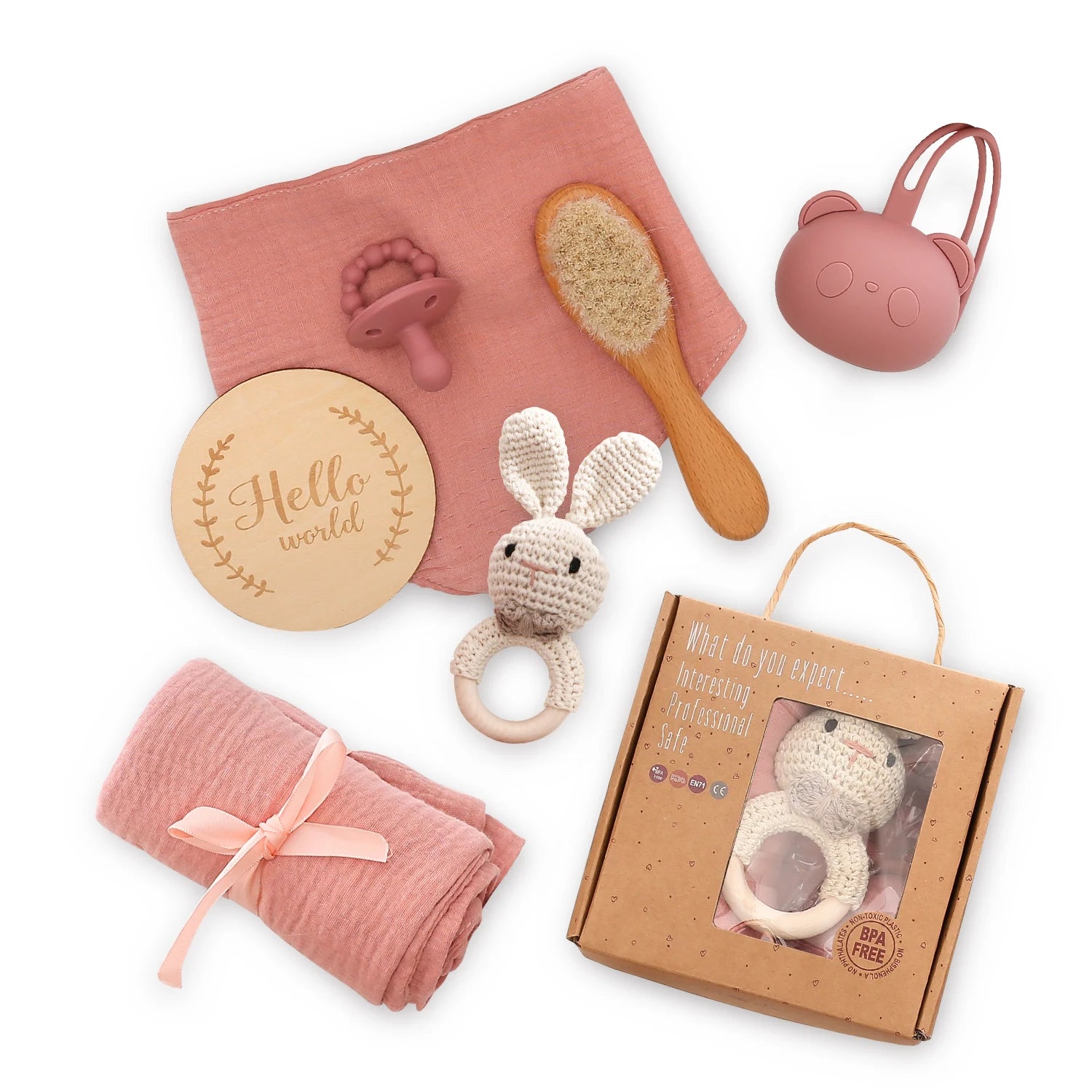 Collection of baby toys and items including a brush, rattle, and swaddle on a white background.