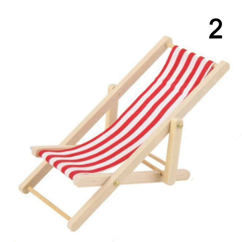 Miniature deck chair with red and white striped fabric on a white background