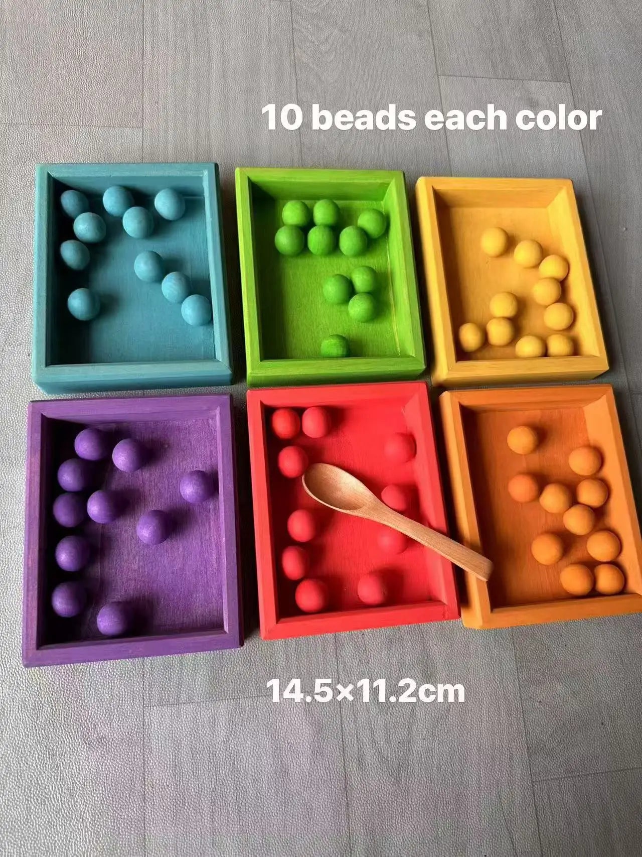 Colorful wooden balls with a wooden spoon on a gray surface