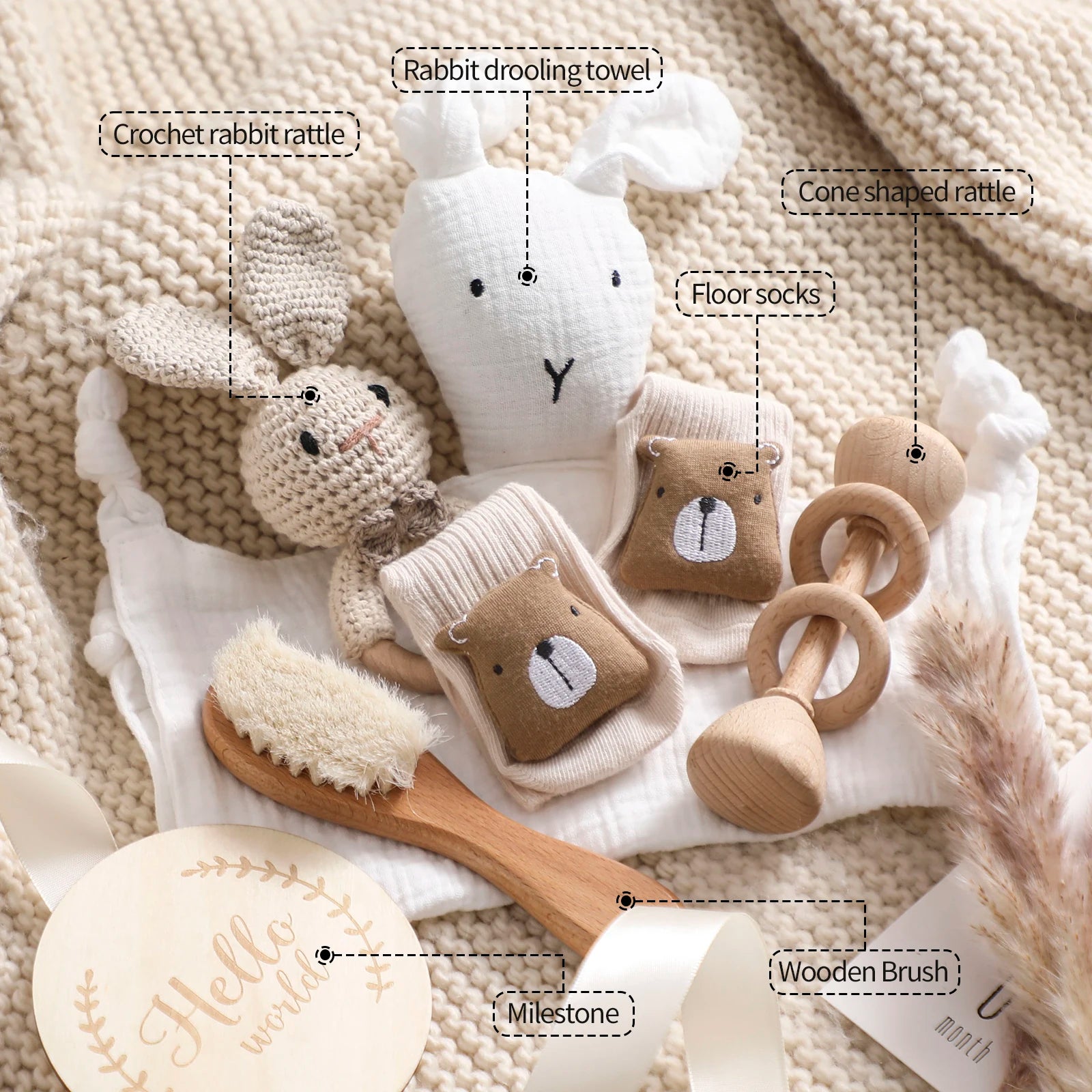 Collection of baby toys and items on a textured surface with labels.