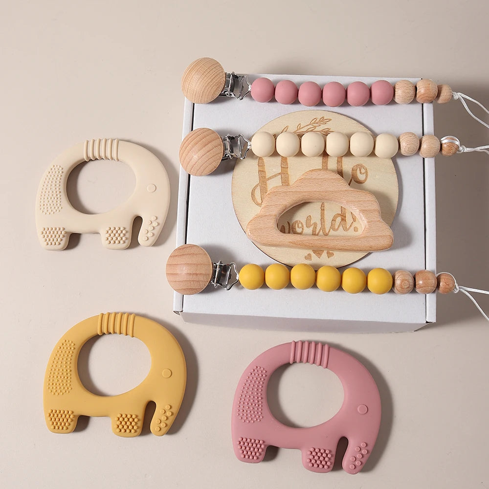 Set of wooden and silicone baby teething toys with a neutral background