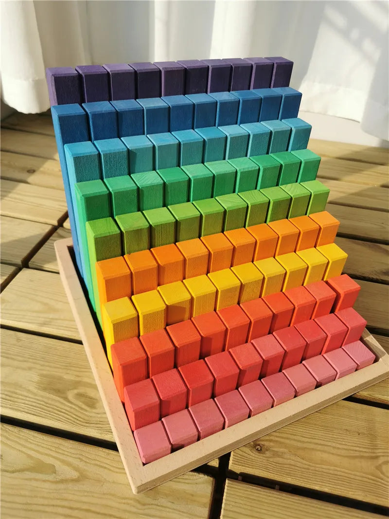 Colorful wooden blocks arranged in a pyramid shape on a wooden surface.