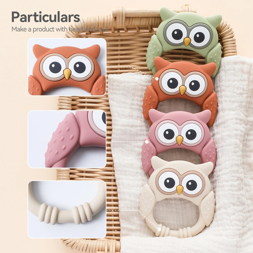 Set of colorful owl-shaped baby teething toys on a textured surface.