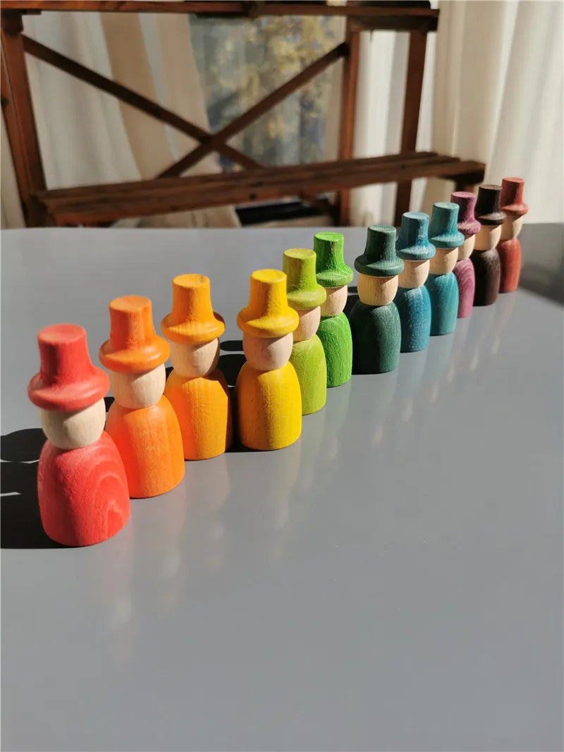 Colorful wooden peg dolls arranged in a row on a reflective surface.
