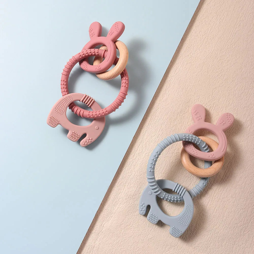 Two silicone teething rings on a light blue and beige background