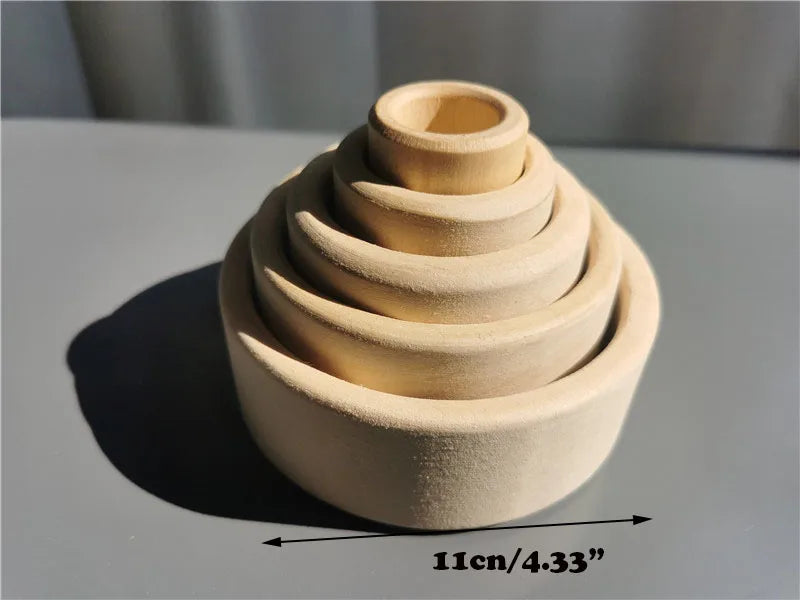 Set of wooden nesting bowls on a gray surface with measurement label