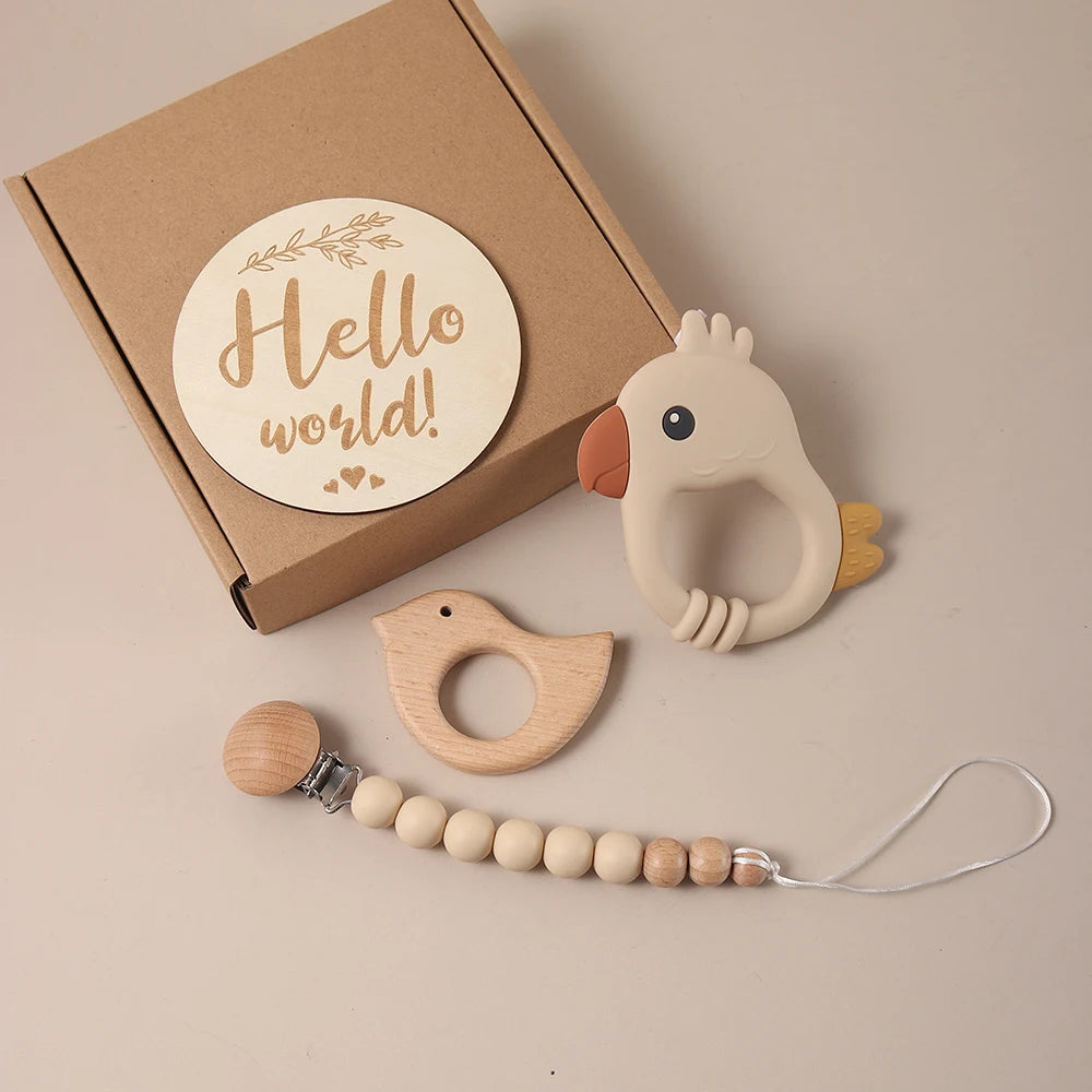 Wooden and silicone baby teether set with 'Hello world!' sign on a beige background