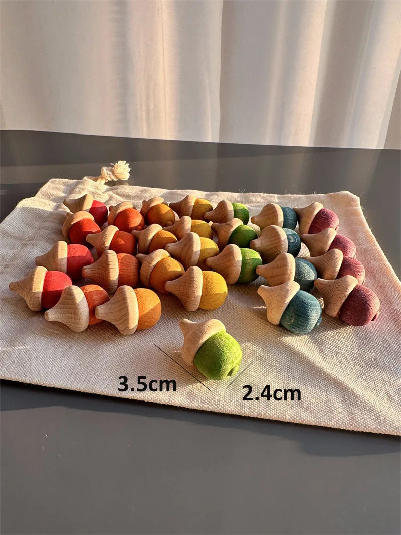 Colorful wooden acorn-shaped toys on a fabric surface with measurements indicated.